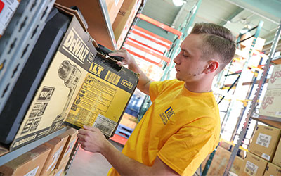 a student pulls an item off the shelf in the industrial distribution lab
