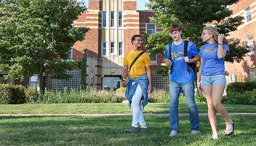 3 Students walking in front of Men's Hall