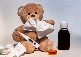 Teddy bear with a tissue and thermometer.