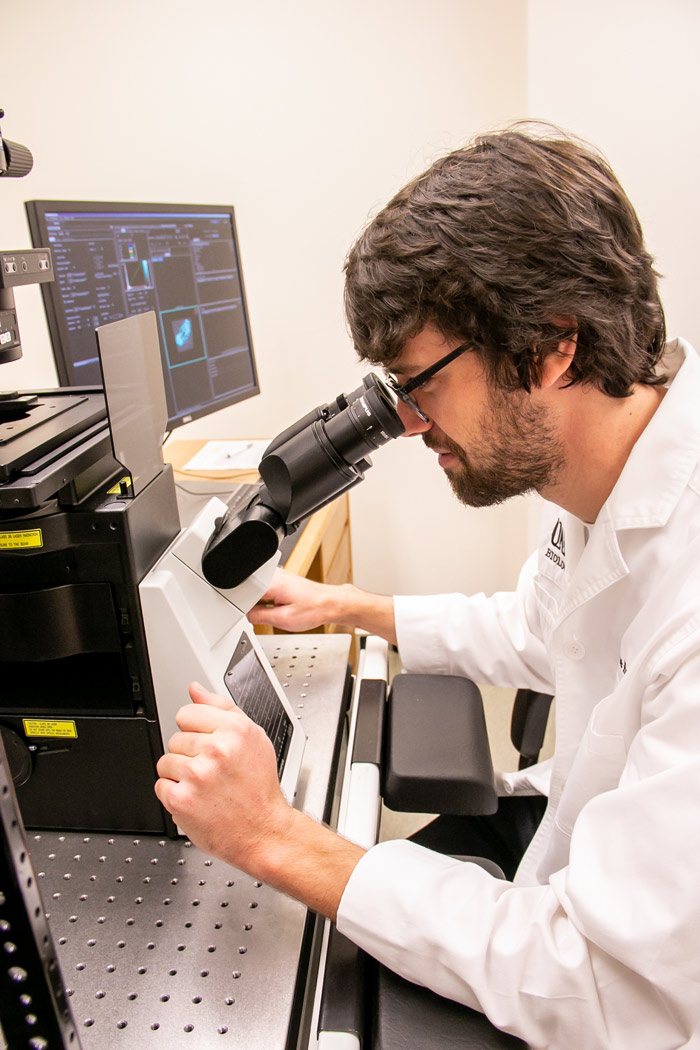 M.S. Biology student, Blase Rokusek, looks through microscope in UNK Biology lab.