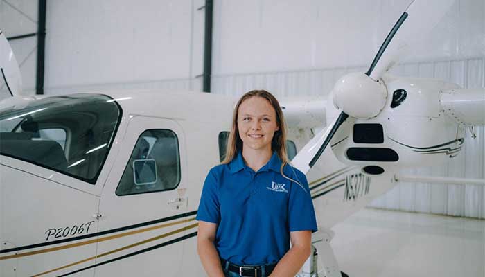 Emily Farley in front of UNK airplane