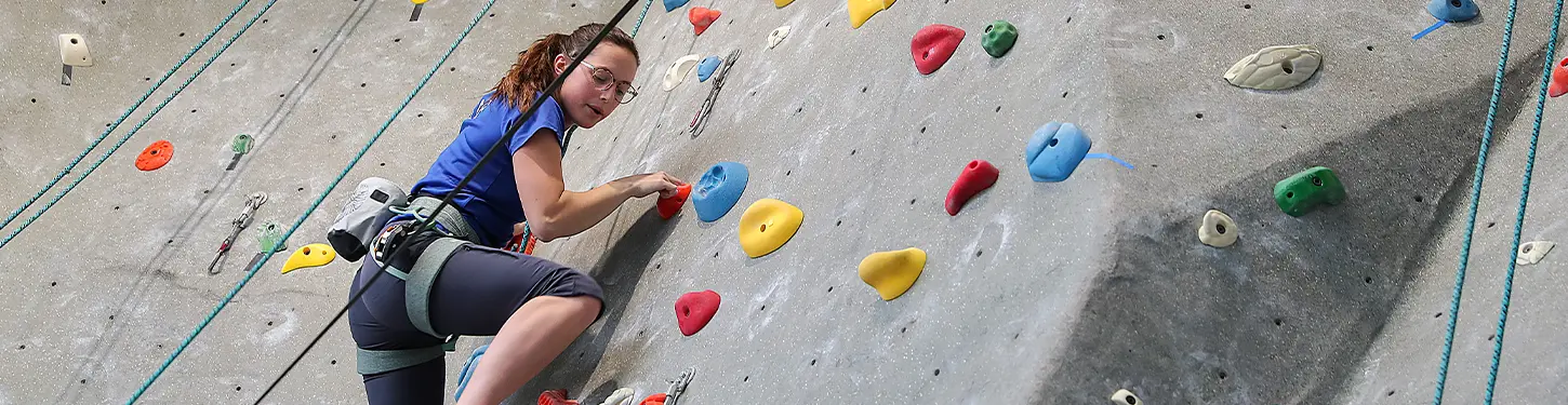 Student climbing rock wall