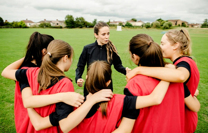 a coach works with a group of student athletes