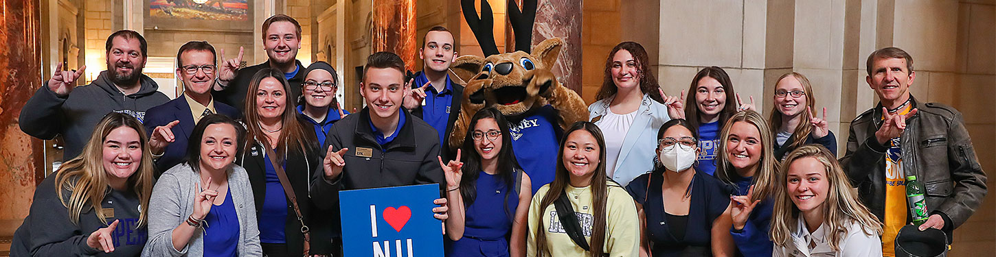 students and staff pose with Louie the Loper in the state capital during I Love NU Day