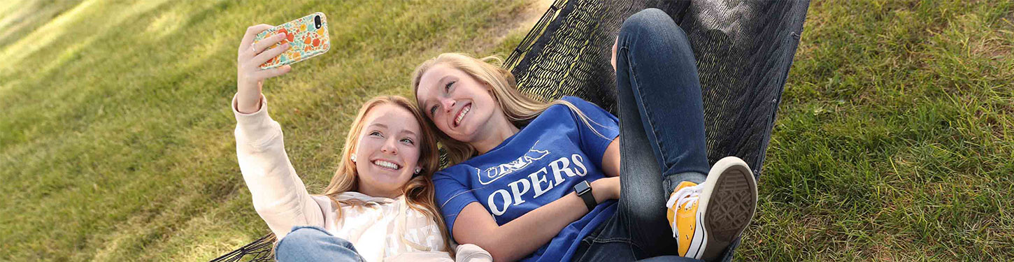 students taking a selfie in a hammock