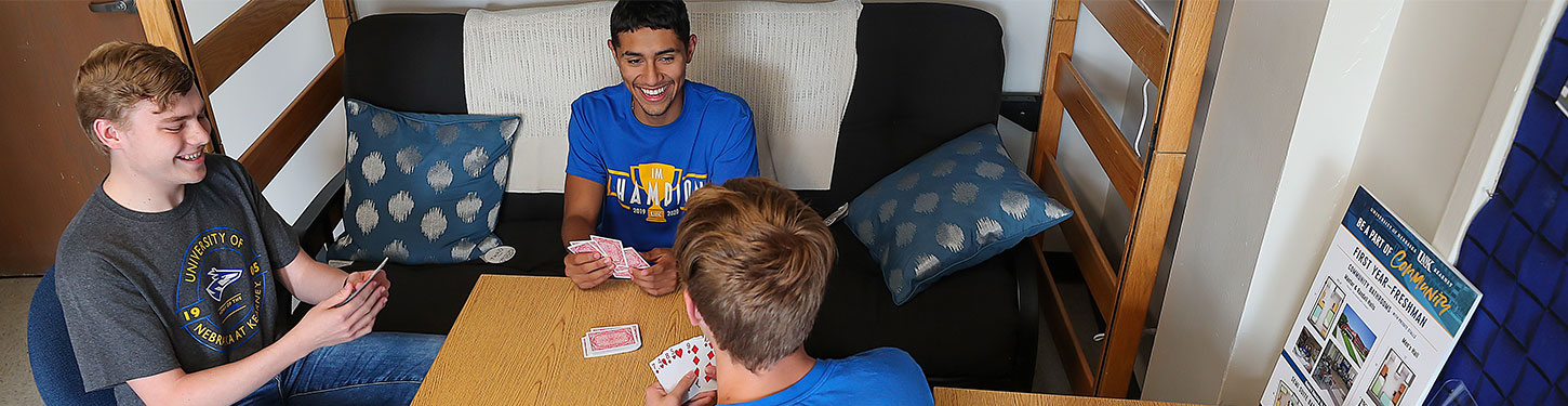 students playing cards in their dorm room