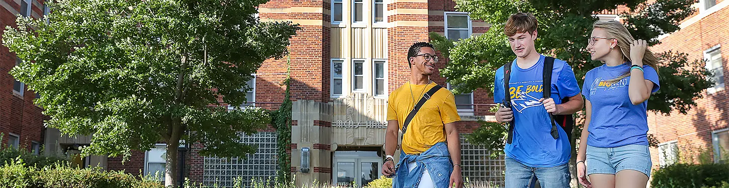 students walking across campus on a sunny afternoon