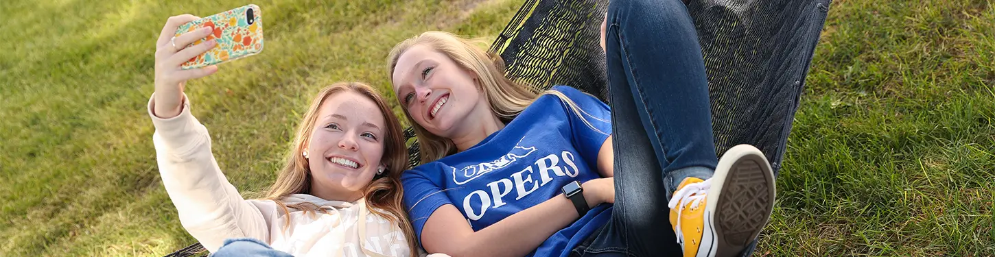 students taking a selfie in a hammock