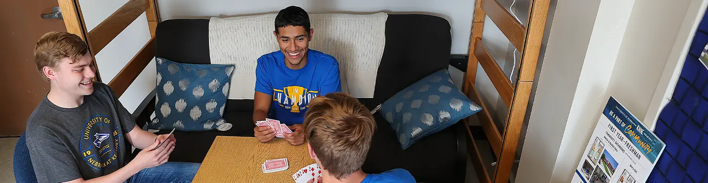 students playing cards in their dorm room