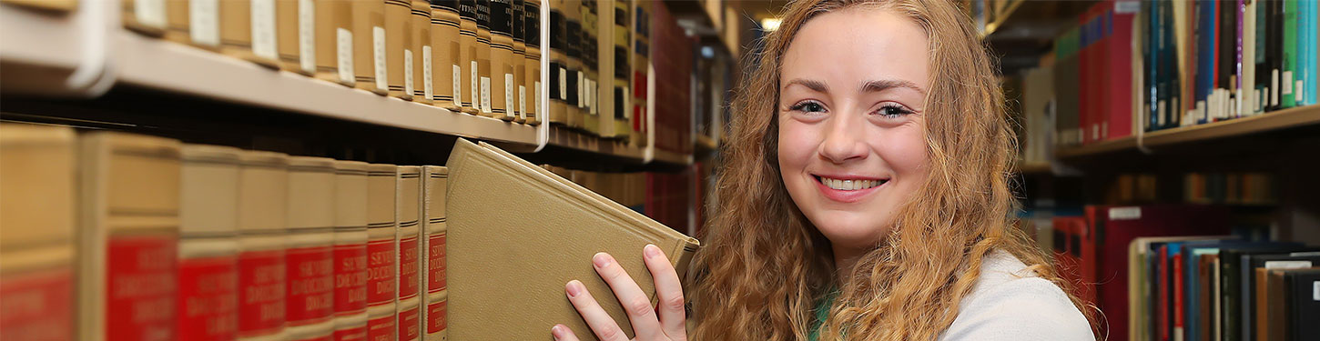 UNK student takes a book of a library shelf