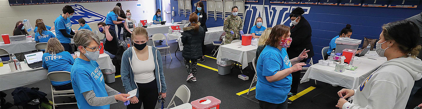 students and staff at a COVID vaccine clinic