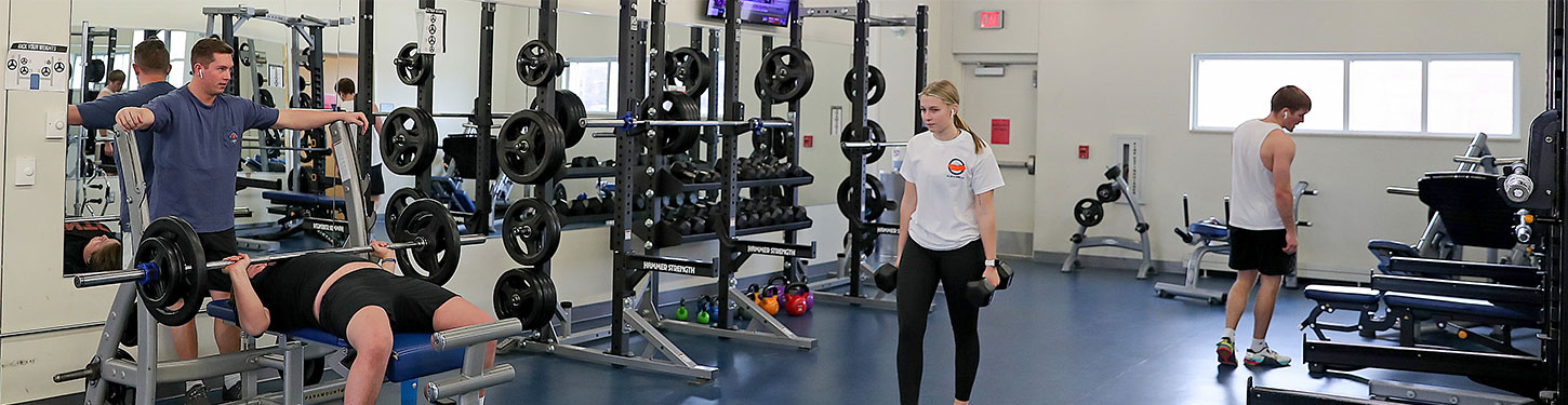 students using weights in the wellness center