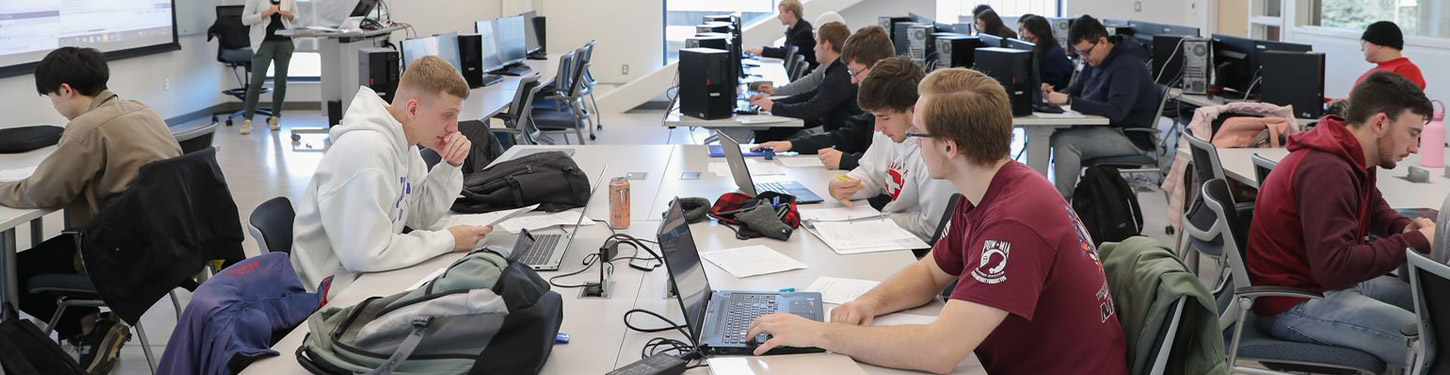 students sitting at tables in a cyber systems class