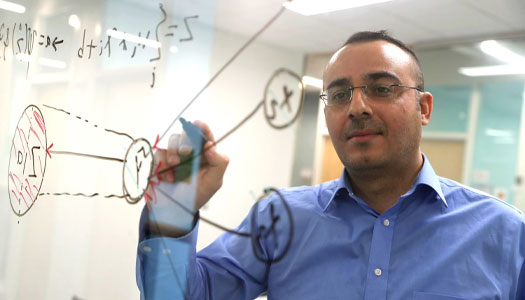 a teacher writes on a transparent white board 