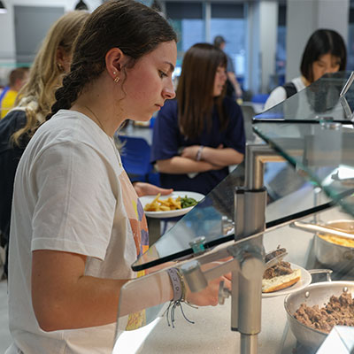 a student serves herself from a buffet line