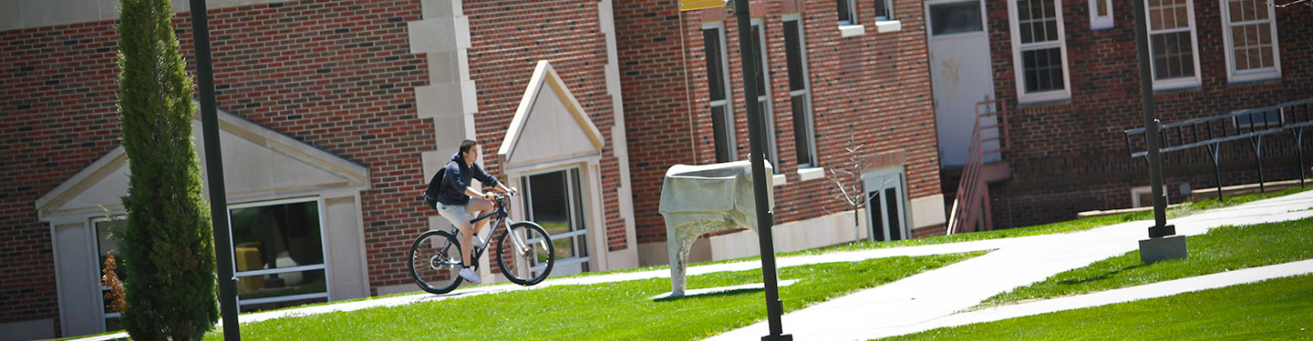 Student on Bike in front of West Center