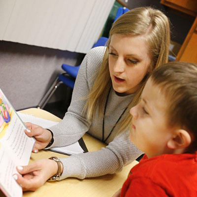 Student reading to child