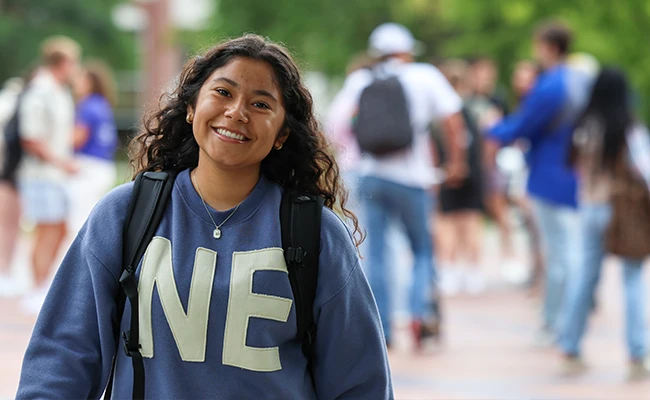 A student smiles for a photo on UNK's campus