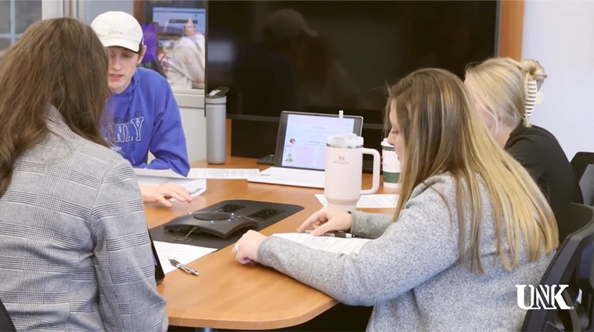 Youtube video thumbnail showing students sitting around a table