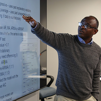 a teacher points to a slide during a lecture