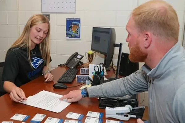 a man and woman talk across a desk