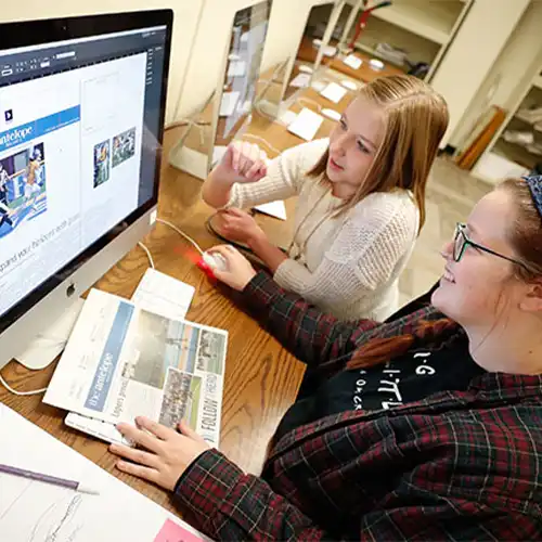 image of journalism students working at a computer
