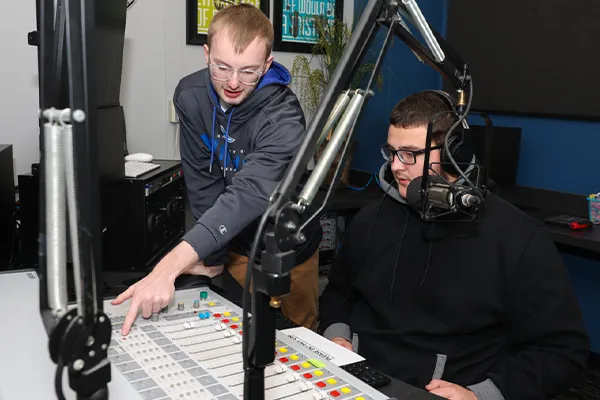 students work with radio broadcasting equipment 