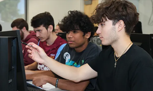 students work at a computer workstation in a class