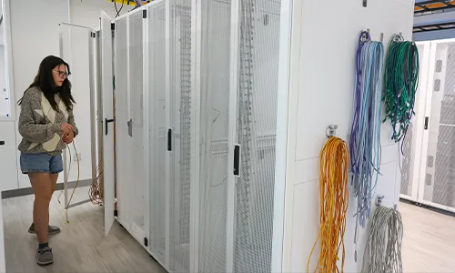 a student works on server stacks in a data center