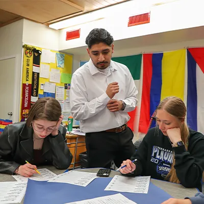 a teacher looks over students' worksheets