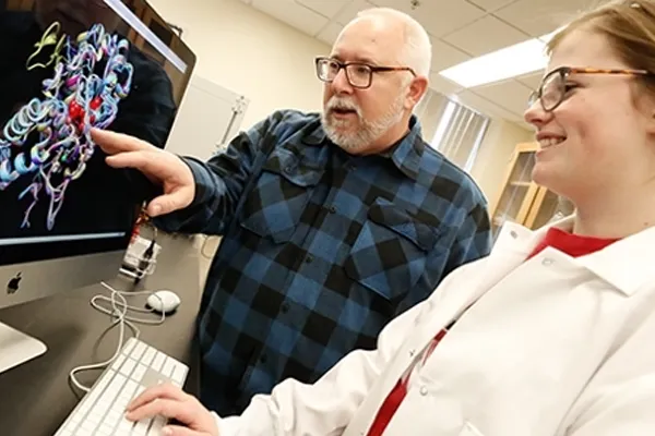 an instructor points out information on a computer screen