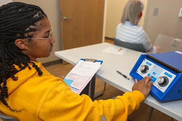 a student works with audiology equipment