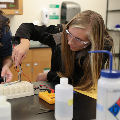 a high school student does an experiment during science day