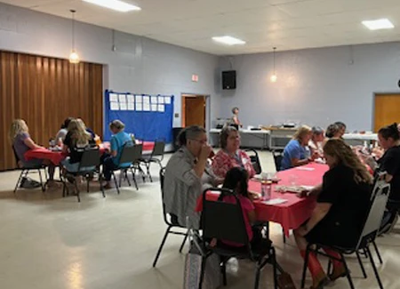 people sit at tables in an event hall