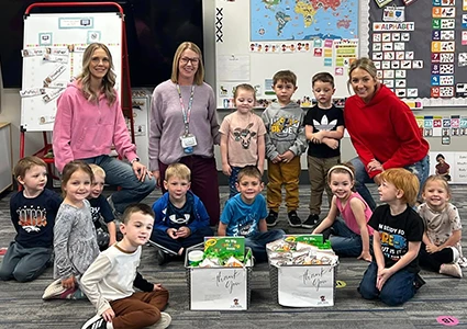 a teacher and her class pose for a group photo