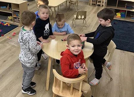 children sit at a table in the learning center