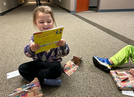 a child smiles holding a book