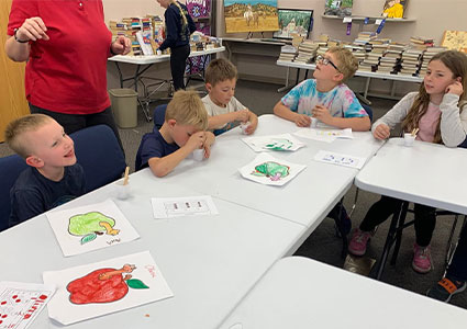 children sit at tables smiling