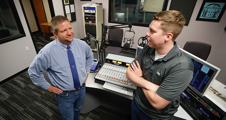 UNK Communication student in the campus radio station speaking to professor Ford Clark