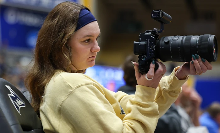 Student photographs a basketball game