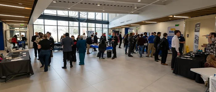 students and professionals walk booths at techfast