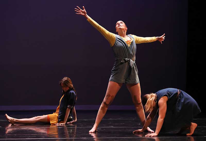 three student performers give a dance recital