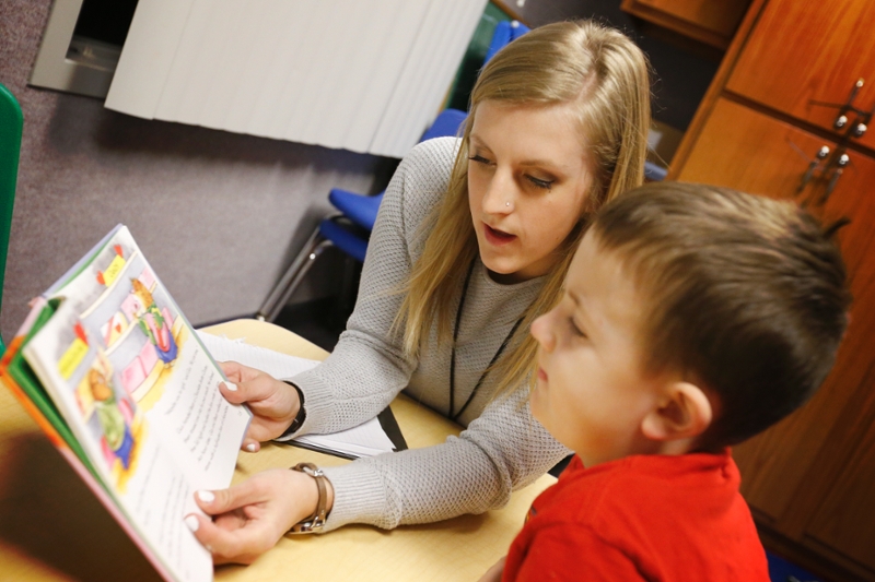Student reading to young child