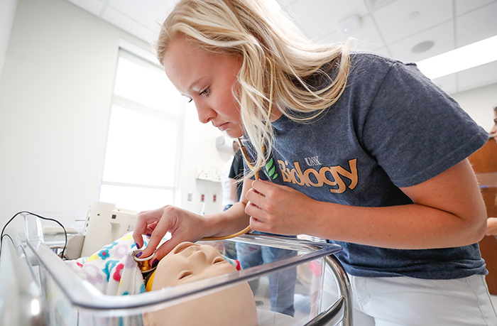 UNK student examining flask of chemicals