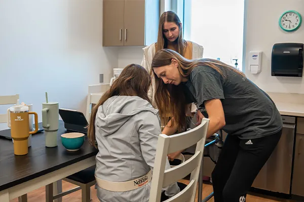 students wrap a lift belt around a patient