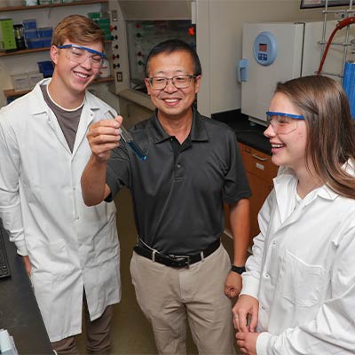 a teacher with students in lab coats