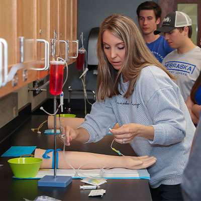a teacher demonstrates a lab technique