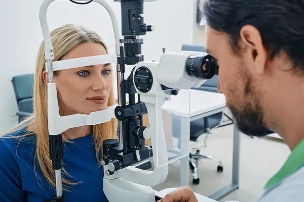 An optometrist works with a patient