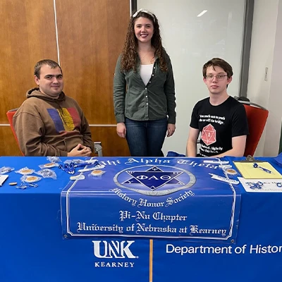 phi alpha theta students sit at a table