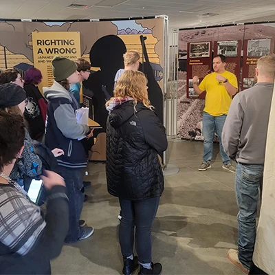 a presenter talks to a crowd at an exhibit